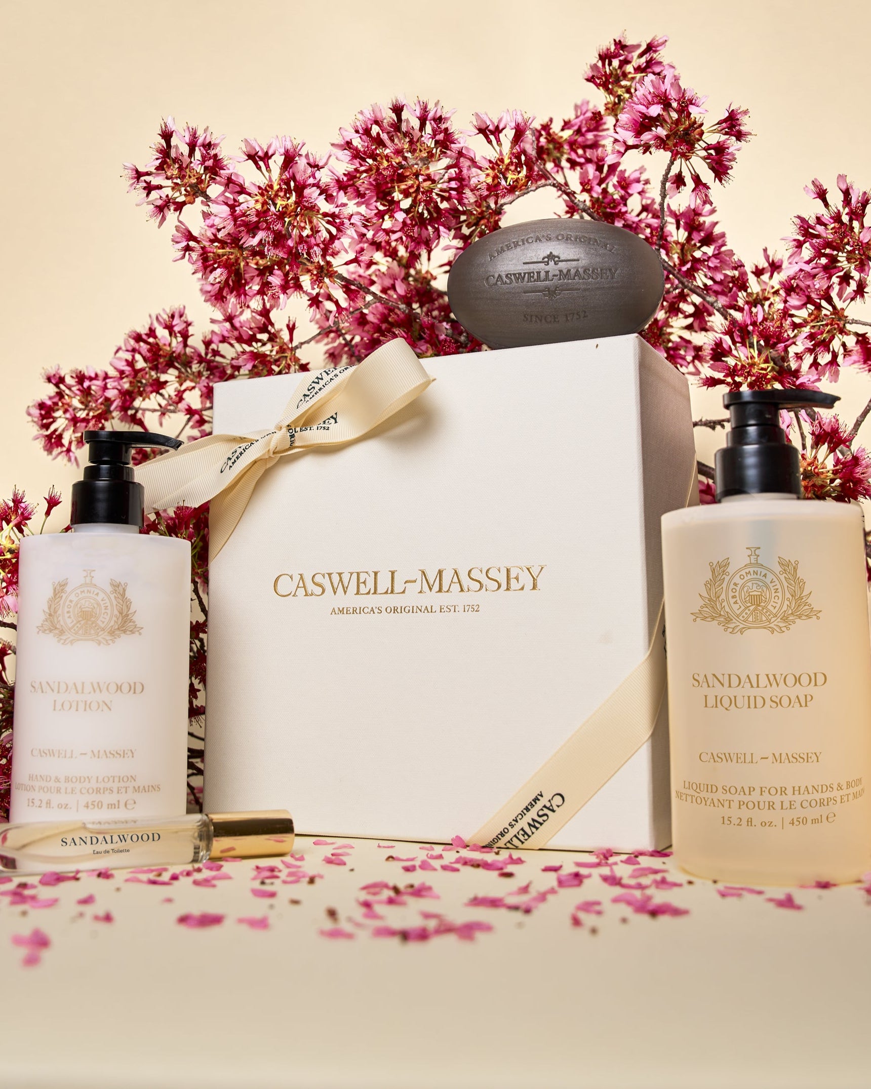 Caswell-Massey Mother's Day Luxe Gift Set in Sandalwood. Featuring Sandalwood Bar Soap, Sandalwood Lotion (15.2oz), Sandalwood Body Wash (15.2oz), and Sandalwood Eau de Toilette (7.5ml) all presented in cream gift box with cream ribbon.